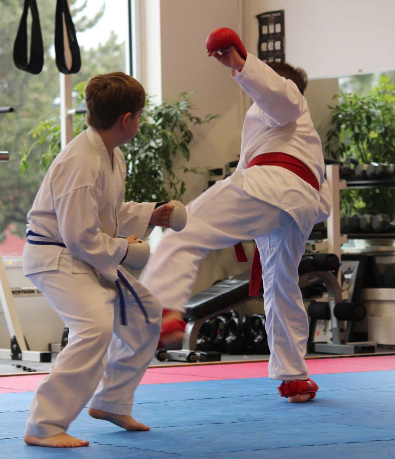 Two students sparring with a high kick